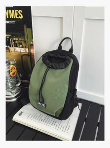Detail eines wasserdichten Canvas-Rucksacks mit olivgrünem Gittermuster und Kordelzugverschluss