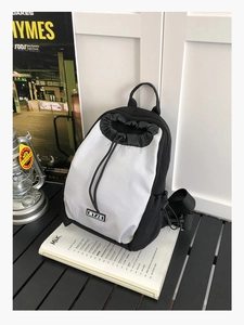 Detail eines wasserdichten Nylon-Rucksacks mit Schwarz-Weiß-Kontrast und MYJC-Logo auf dem Tisch