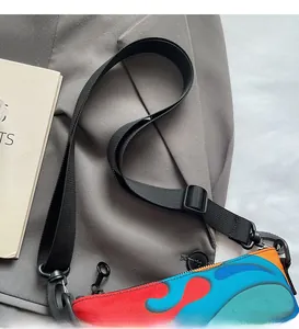 Detail of adjustable nylon shoulder strap on abstract colorful crossbody square bag