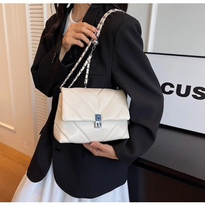 Vue détaillée du sac en cuir matelassé blanc avec motif en V et bandoulière chaîne