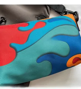 Detail of colorful wavy patterned crossbody bag with durable black buckle and strap