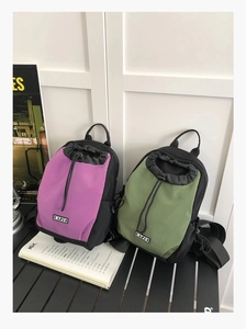 Nahaufnahme von zwei wasserdichten Nylon-Rucksäcken in Lila und Grün auf einem Tisch