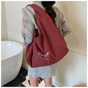 Close-up of a large dark red checkered tote bag with Ourvile Party embroidery detail