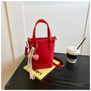 Vue détaillée du mini sac seau rouge avec pendentif cœur et cordon tressé décoratif