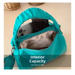 Internal capacity of green Boston bag showing smartphone and wallet inside