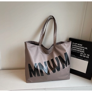 Detail view of large grey-brown nylon tote bag with black MNWM letter print