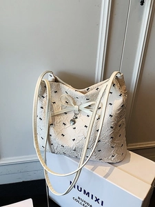 Sac seau blanc minimaliste avec motifs nœuds noirs et pendentif cœur argenté chic