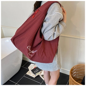 Detail of red checkered tote bag with Our fav Party text and durable zipper closure