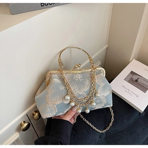 Dettaglio ricami floreali e frange dorate con perle su borsa azzurra stile vintage