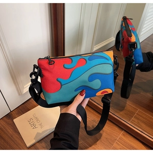 Detail view showing abstract color-block nylon crossbody bag via mirror reflection