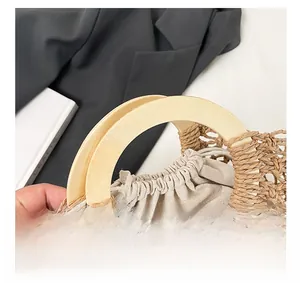 Detail showing the smooth semicircular wooden handle and hollow woven straw texture