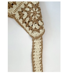 Detailed macro view of the crochet floral pattern and beige hand-woven fabric texture