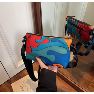 Detail of color-block crossbody bag featuring fluid abstract patterns and adjustable strap