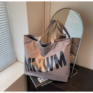 Detailed view of spacious lavender tote bag with MNWM lettering and wide shoulder straps