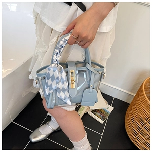Détail du sac seau bleu clair en PVC transparent avec foulard et fermoir doré