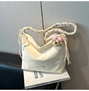 Minimalist cream hobo bag with unique ruched strap and cute bear plush charm detail