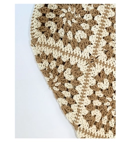 Detail of hand-woven crochet patterns in beige and khaki for a stylish tote bag