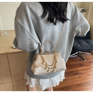 Dettaglio borsa jacquard vintage con nappa di perle e manico ad anello dorato