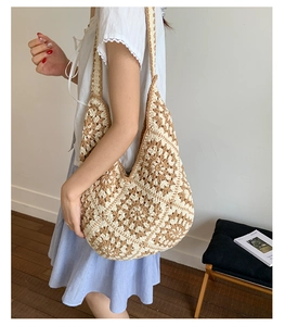 Detail of hand-woven sunflower pattern on a hollow crochet shoulder tote bag