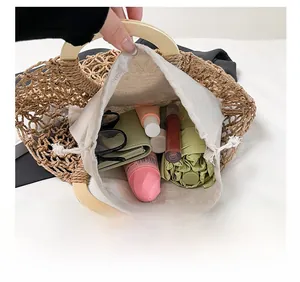 Internal view of hollow woven straw handbag showing capacity for umbrella and cosmetics