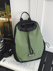 Olivgrüner Mini-Rucksack mit Kordelzug und MYJC-Logo auf hölzernem Hintergrund