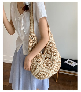Detail of hand-woven tote bag with beige and brown floral crochet patterns and wide strap