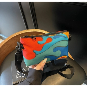 Detail of colorful abstract wave pattern crossbody bag with black nylon shoulder strap