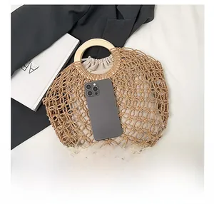 Detailed close-up of woven net tote with wooden handles and drawstring inner bag