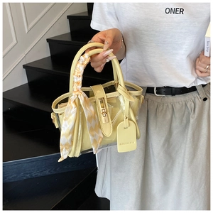 Détail du sac seau jaune en PVC transparent avec foulard en soie et fermoir métal