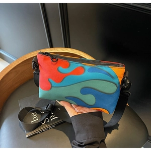 Detail of color-block crossbody bag with abstract wave patterns and adjustable strap