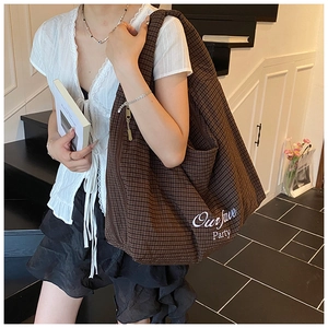 Detail of a large brown checkered hobo bag with white Our fave Party embroidery