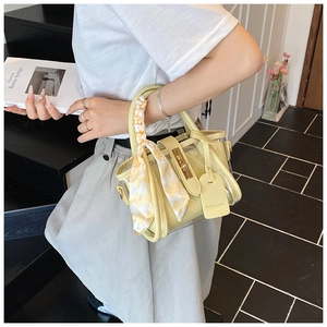 Détail du sac seau jaune en PVC transparent avec décoration de foulard en soie
