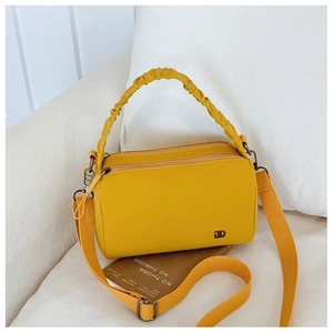 Detail of ginger yellow crossbody bag with ruched cloud handle and woven shoulder strap