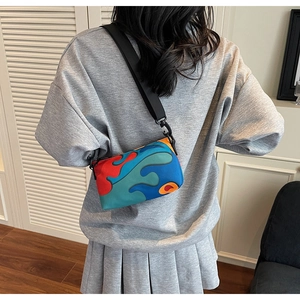 Detailed view of back-worn crossbody bag featuring vibrant wave pattern and nylon strap
