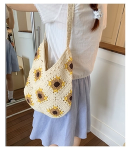 Detail of hand-woven crochet hobo bag with yellow sunflower patterns and wide strap
