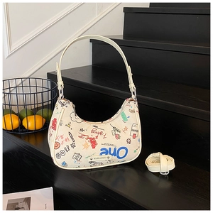 Close-up of graffiti baguette crescent bag on stairs with detachable shoulder strap
