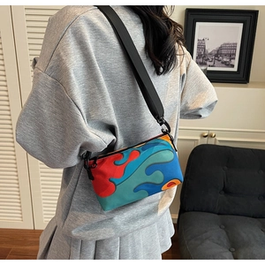 Lifestyle view of women's compact crossbody bag with colorful abstract wave pattern