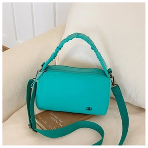 Close-up of turquoise crossbody bag with ruched handle and metal logo detail