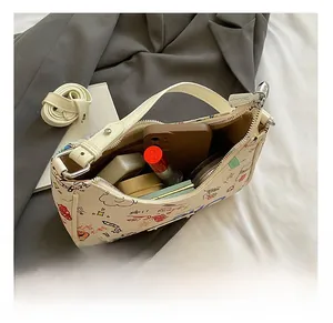 Internal view of graffiti crescent bag showing storage space for phone and makeup
