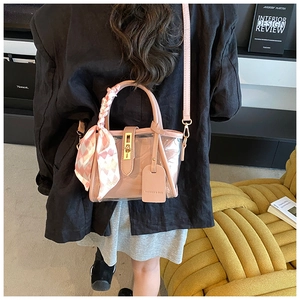 Sac seau rose translucide avec ferrures dorées et détail de foulard en soie