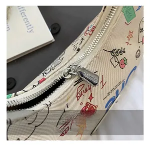 Detail of canvas shoulder bag with colorful graffiti prints and smooth silver metal zipper