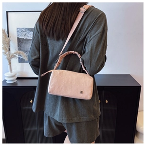 Detail of light pink Boston bag showing textured fabric and stylish ruched handle
