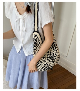 Close-up of bohemian crochet tote bag featuring floral knit patterns and soft cotton strap