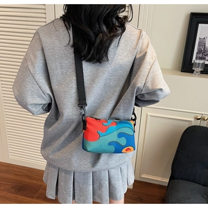 Adjustable shoulder strap and colorful patchwork detail of the crossbody nylon bag