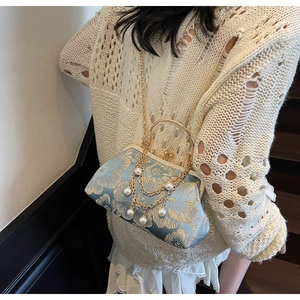 Dettaglio del ricamo azzurro sulla borsa vintage con chiusura a scatto e nappe di perle
