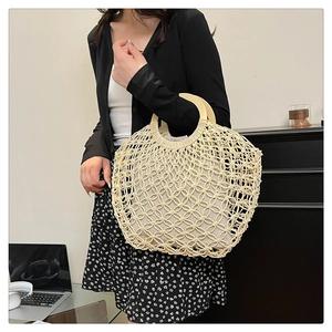 Detail of hollow woven beach bag with round wooden handles and fabric lining insert