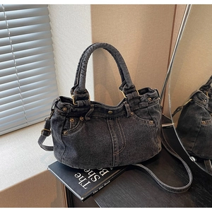 Dettaglio borsa tote in denim grigio scuro lavato con borchie metalliche e cuciture tasca