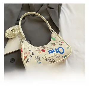 Detail of cream hobo bag with graffiti print and a detachable shoulder strap