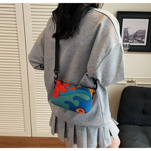 Detail of adjustable strap and multi-colored patchwork design on crossbody bag