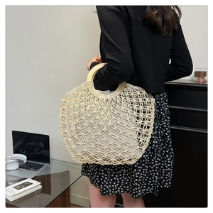 Detail of bohemian hollow woven tote bag featuring round wooden handles and cotton lining